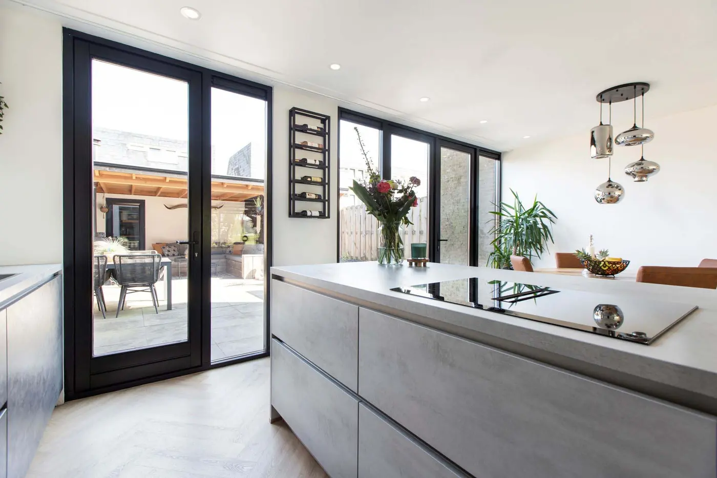 Moderne keuken met kookeiland en zwarte kozijnen